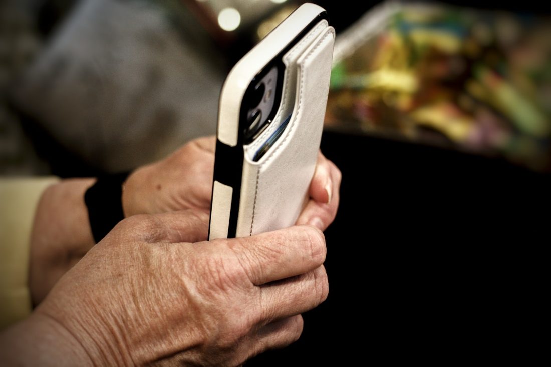 A hand holding a phone, about to check an unknown number
