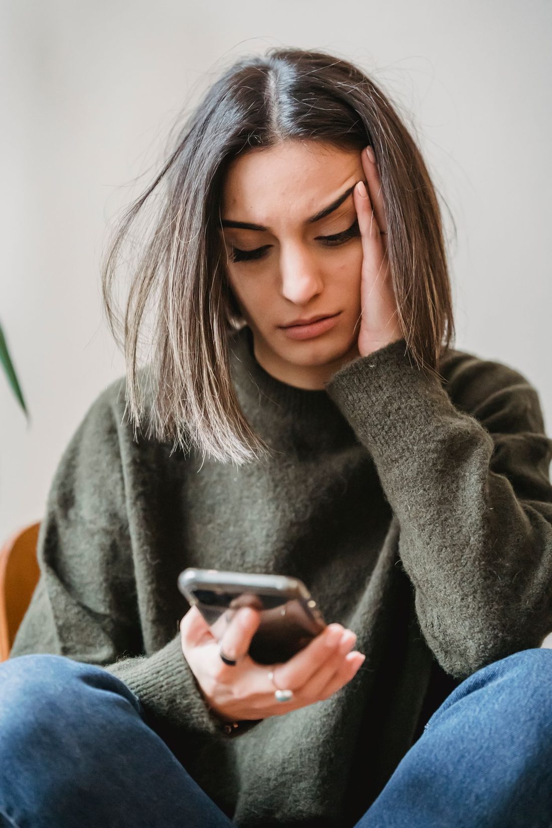 A person looking uneasily at an unknown number on their phone